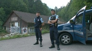 Gendarmes stand by a vehicle on a road near Annecy Lake in Chevaline, southeastern France, in this still image taken from video