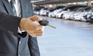 Businessman hand giving a car key - car sale & rental business c